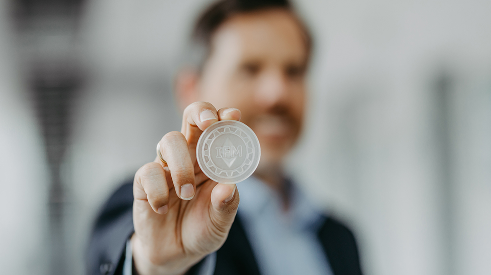 Prof. Dr. Elmar Lukas hält eine Kryptowährung in der Hand