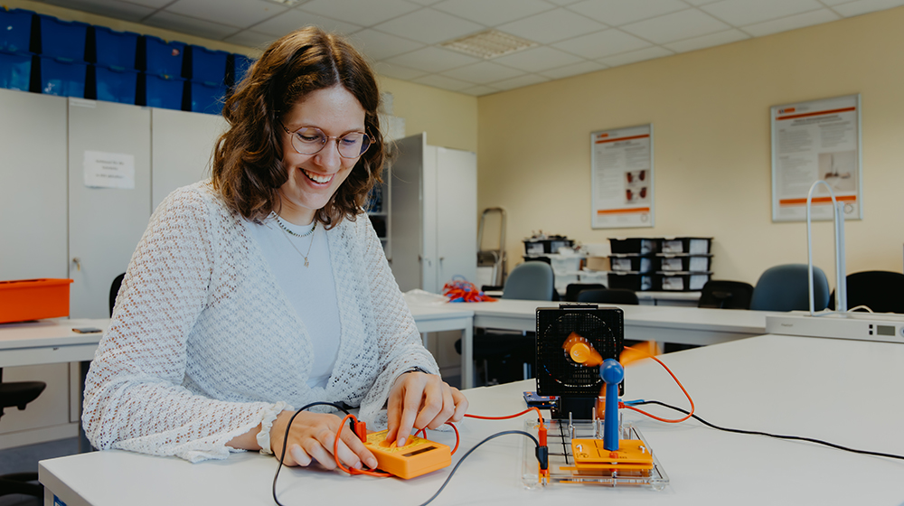 Madlen Moritz sitzt an einem Tisch im SchülaTech und programmiert einen Schmelzdrahtschneider für Styropor (c) Anna Friese Uni Magdeburg